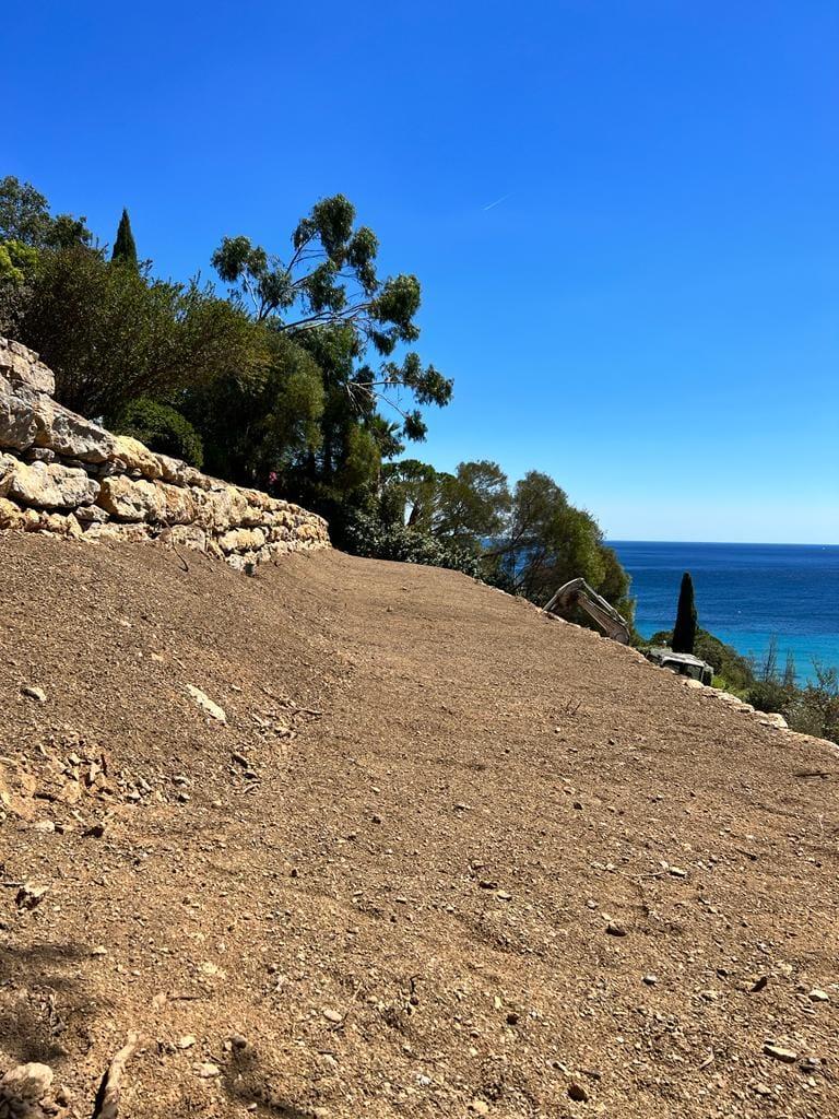 Aménagement talus vue mer avec mur de pierre et allée côte varoise